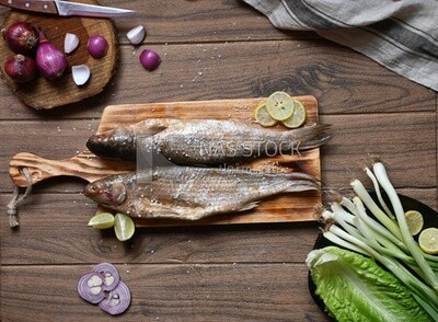 Smoked herring on a Cutting and Serving Board, lemon and onion, traditional food, smoked fish