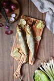 Smoked herring on a Cutting and Serving Board, lemon and onion, traditional food, smoked fish