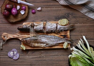 Smoked herring on a Cutting and Serving Board, lemon and onion, traditional food, smoked fish