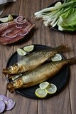 Smoked herring on a Cutting and Serving Board, lemon and onion, traditional food, smoked fish