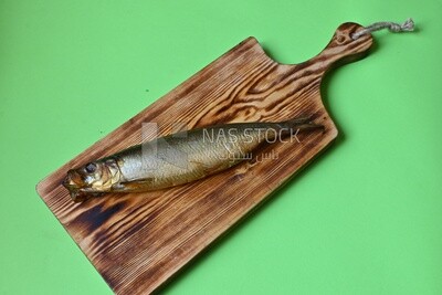 Smoked herring on a Cutting and Serving Board, lemon and onion, traditional food, smoked fish