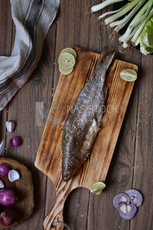 Smoked herring on a Cutting and Serving Board, lemon and onion, traditional food, smoked fish