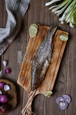 Smoked herring on a Cutting and Serving Board, lemon and onion, traditional food, smoked fish