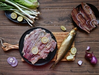 Smoked herring on a Cutting and Serving Board, herring fillet with lemon on a plate, lemon and onion, traditional food, smoked fish
