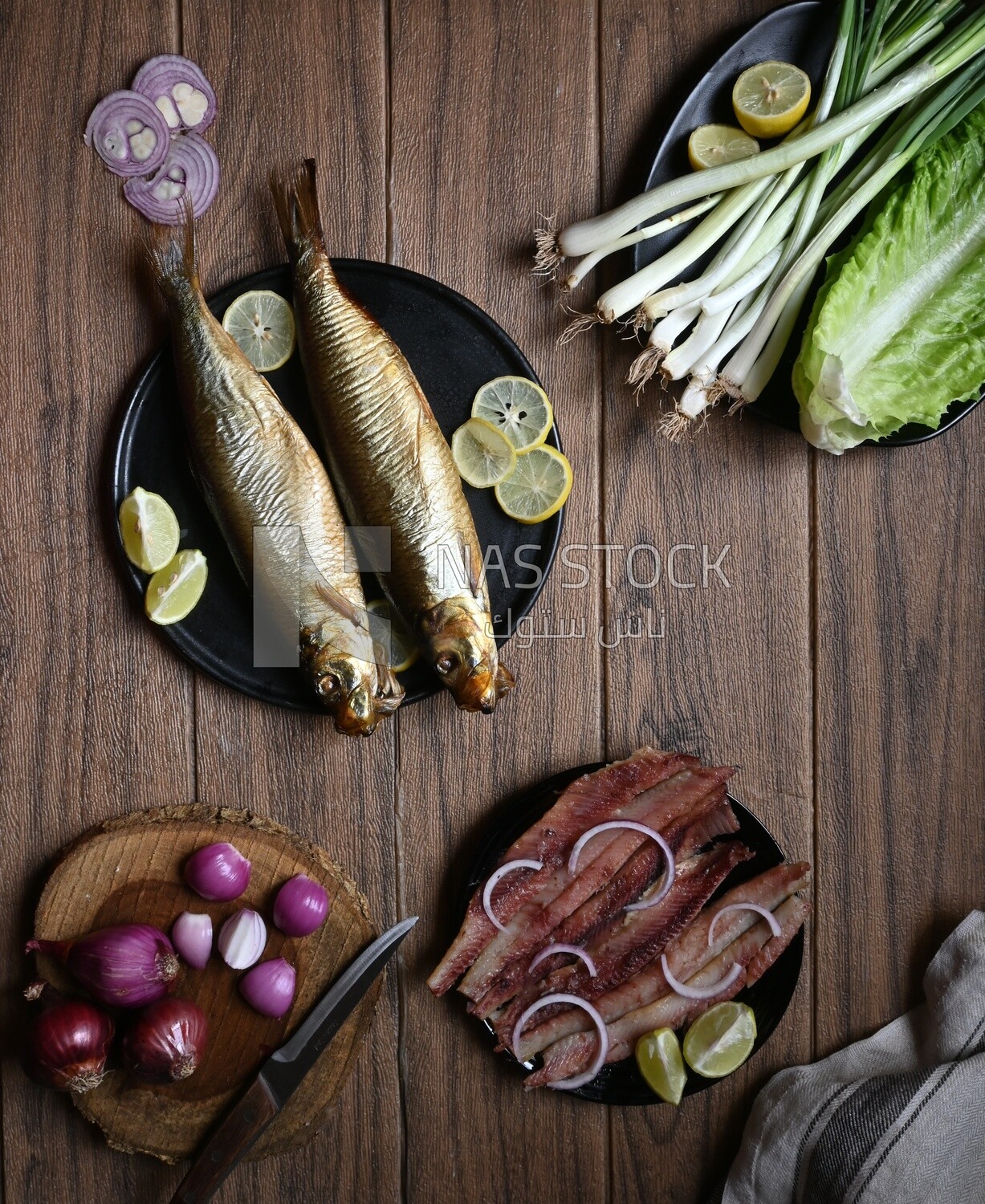 Smoked herring on a Cutting and Serving Board, herring fillet with lemon on a plate, lemon and onion, traditional food, smoked fish