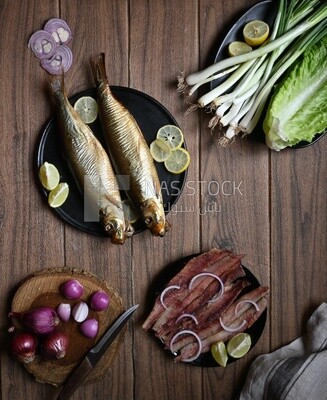 Smoked herring on a Cutting and Serving Board, herring fillet with lemon on a plate, lemon and onion, traditional food, smoked fish