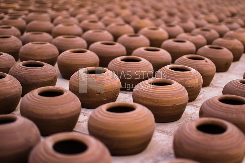 Pottery stacked on the ground under the sun to dry , Pottery , Professions and crafts