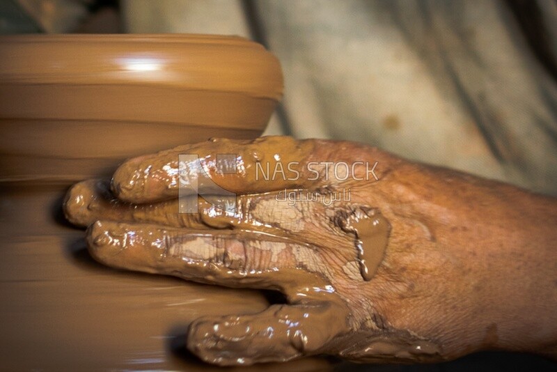 The pottery maker craftsmanship works with his hands to shape the clay , Pottery , Professions and crafts
