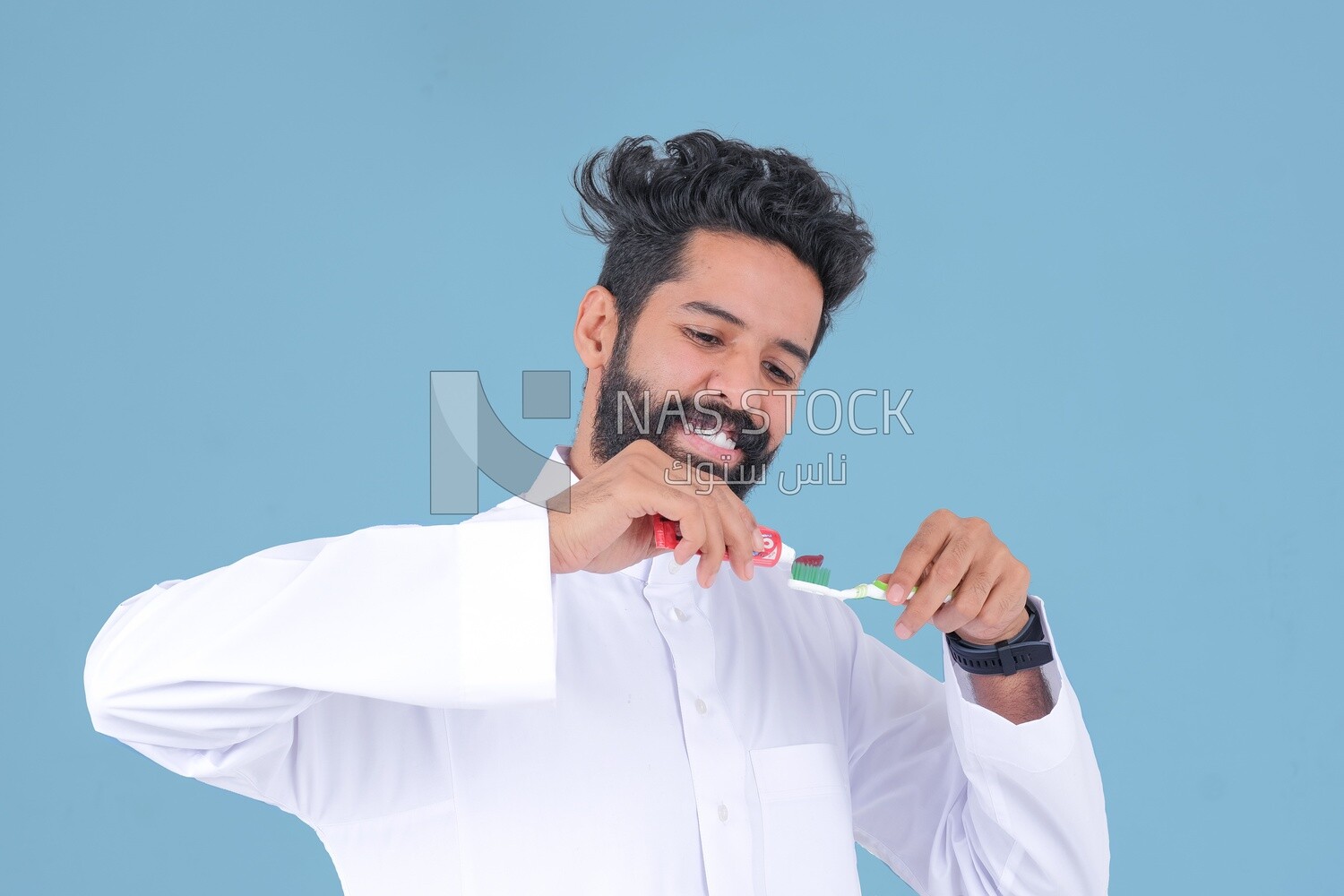 Saudi man holding a toothbrush, brushing his teeth with toothpaste, skincare and hygiene, self-care, Saudi model, white background