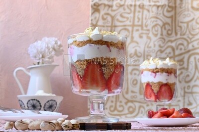 Cup of kunafa with strawberries and cream with a few nuts