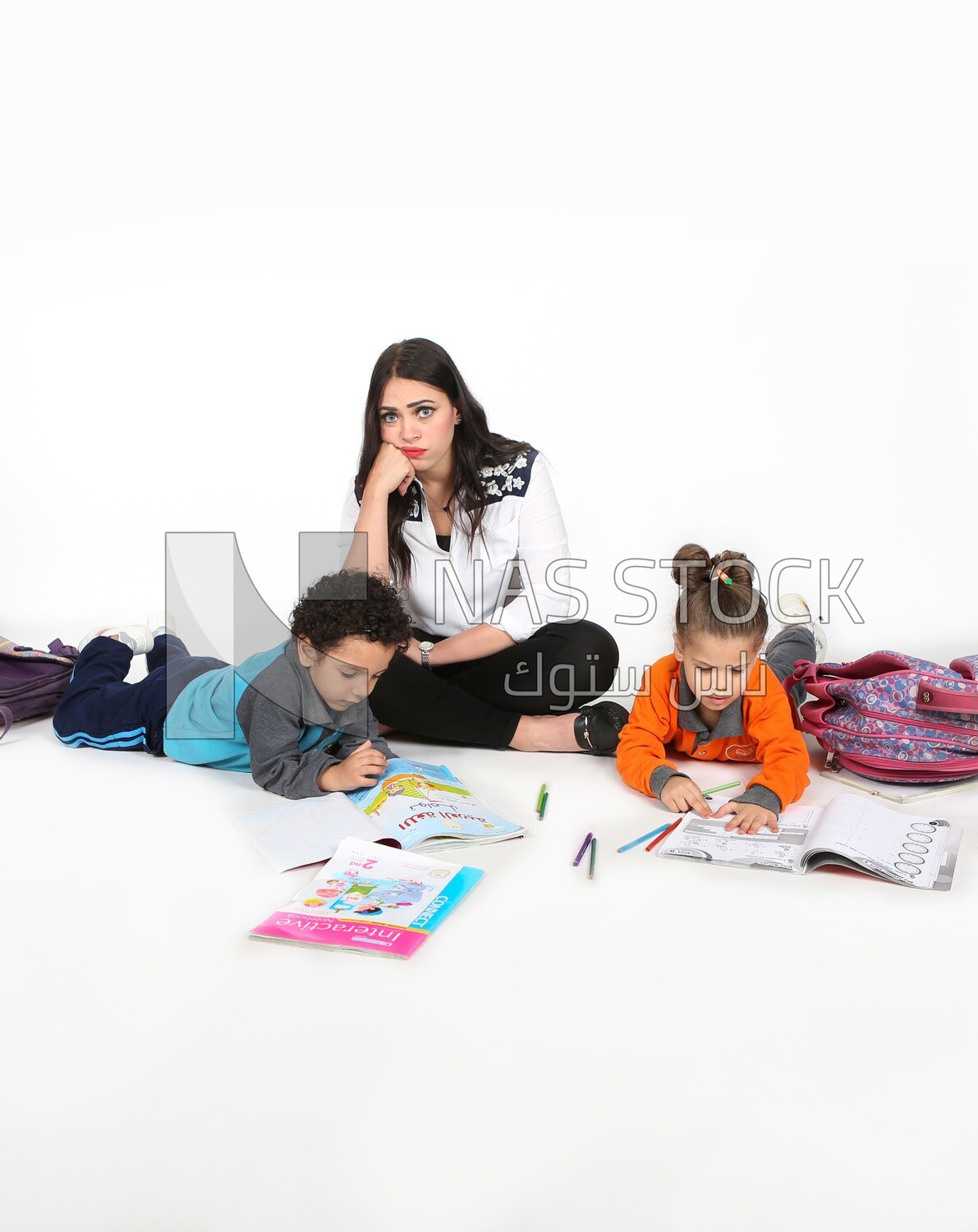 A mother sitting with her kids studying
