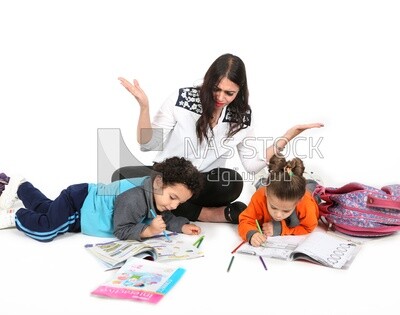 A mother sitting with her kids studying