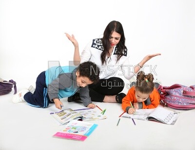 A mother sitting with her kids studying