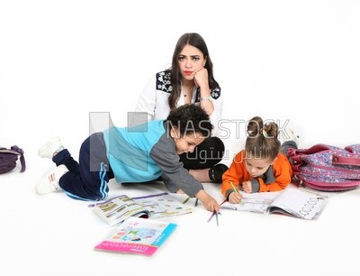 ام تجلس مع اطفالها يدرسون