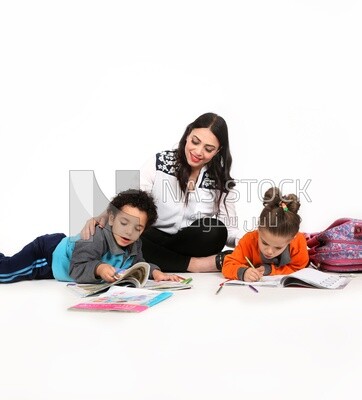 A mother sitting with her kids studying