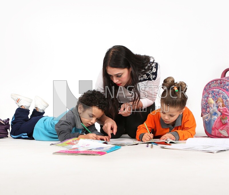 A mother sitting with her kids studying