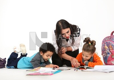 A mother sitting with her kids studying