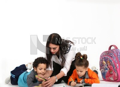 A mother sitting with her kids studying