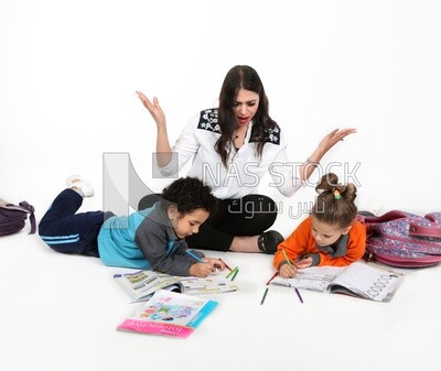 A mother sitting with her kids studying