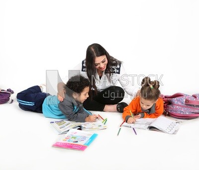 A mother sitting with her kids studying