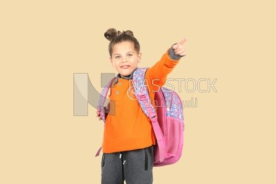 A schoolgirl wearing her bag and pointing
