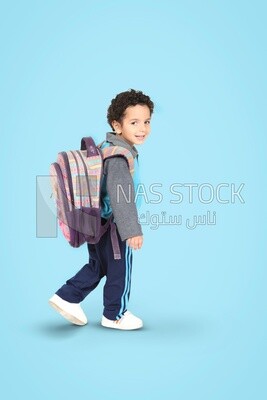 A boy wearing his bag on a blue background