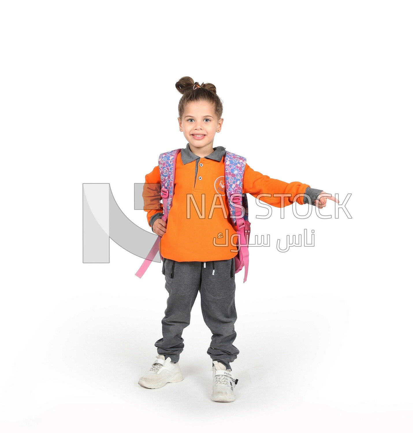 A schoolgirl wearing her bag and pointing