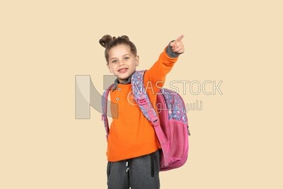 A schoolgirl wearing her bag and pointing