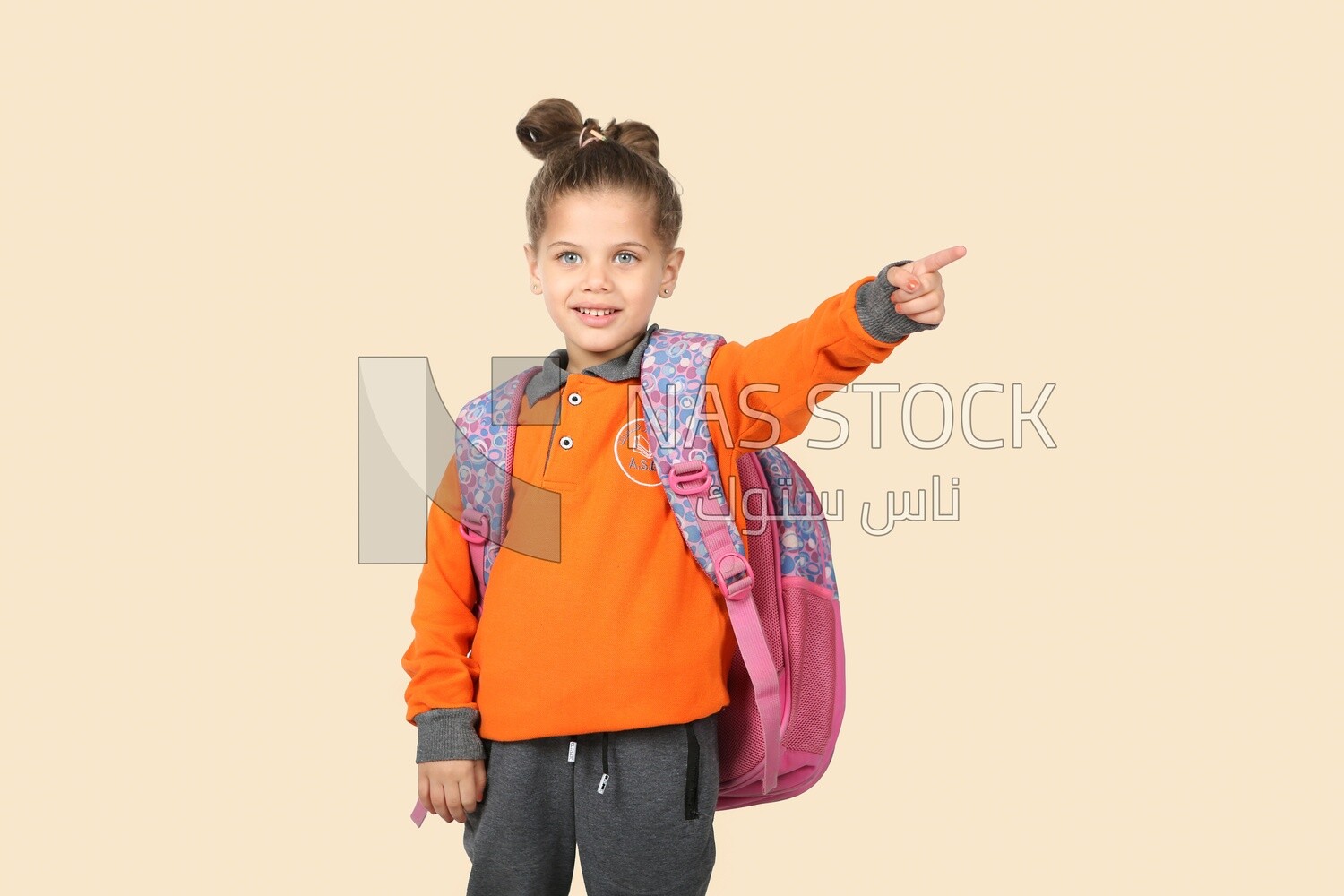 A schoolgirl wearing her bag and pointing
