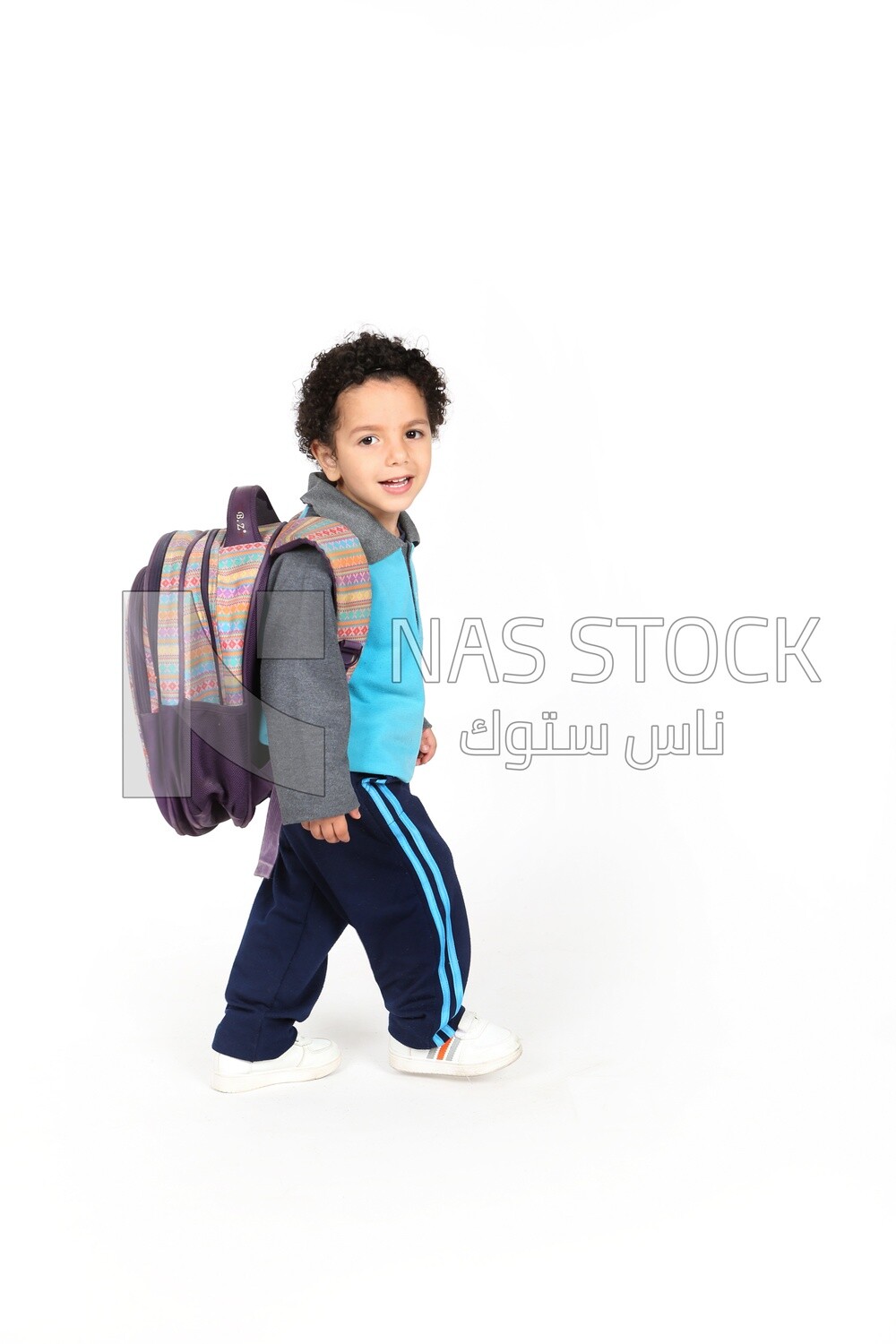 A boy wearing his bag on a white background