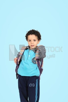A boy wearing his bag on a blue background