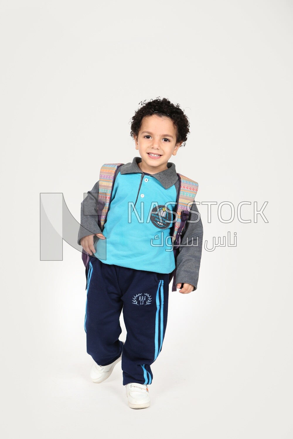 A boy wearing his bag on a white background