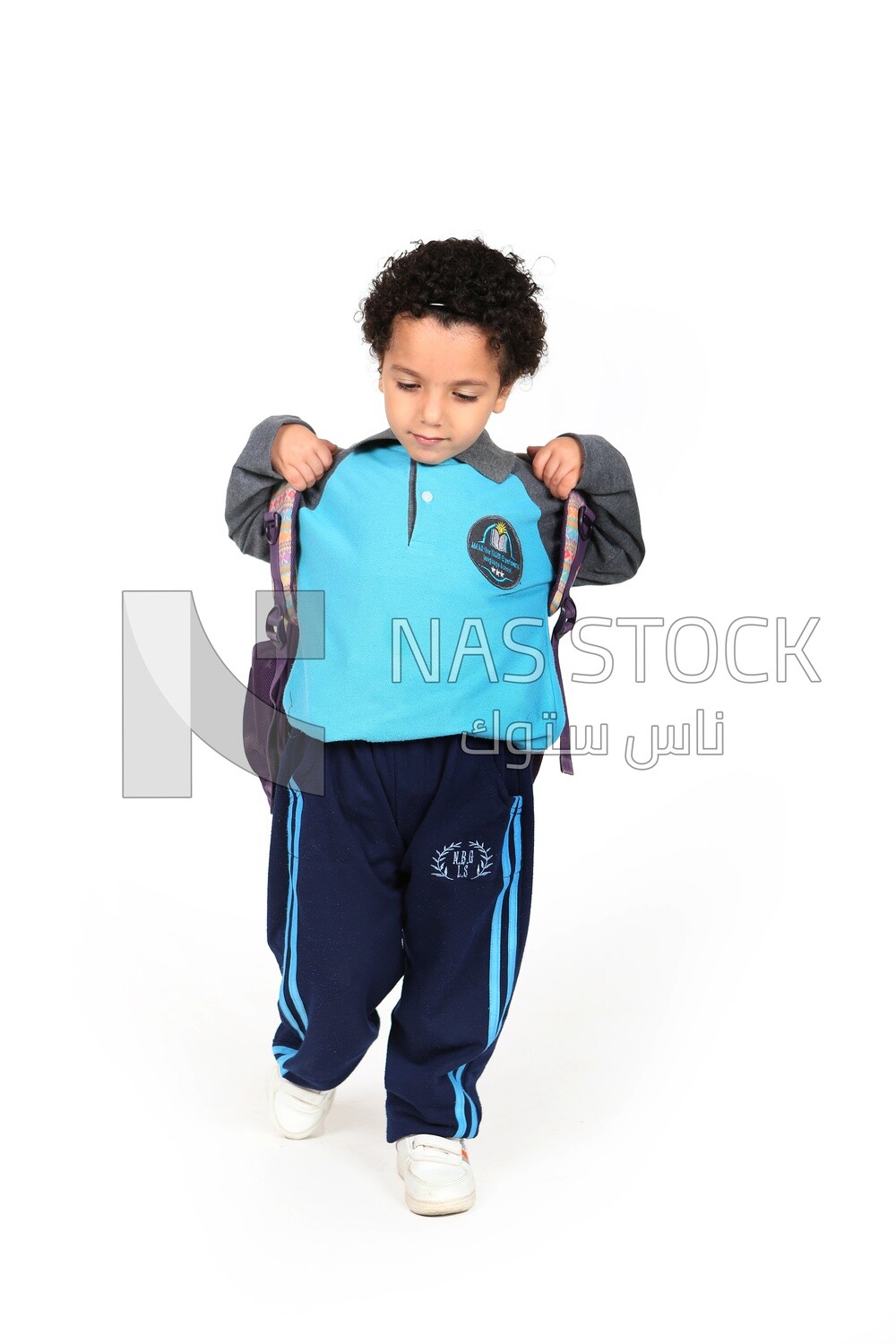 A boy wearing his bag on a white background