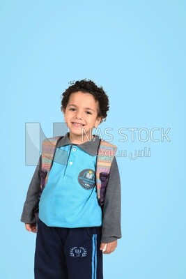 A boy wearing his bag on a blue background
