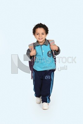 A boy wearing his bag on a blue background