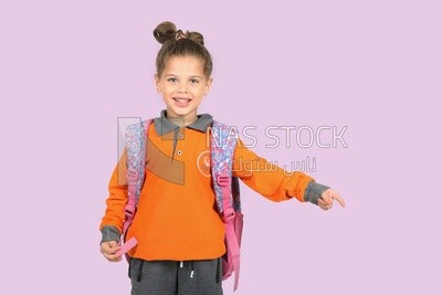 A schoolgirl wearing her bag and pointing