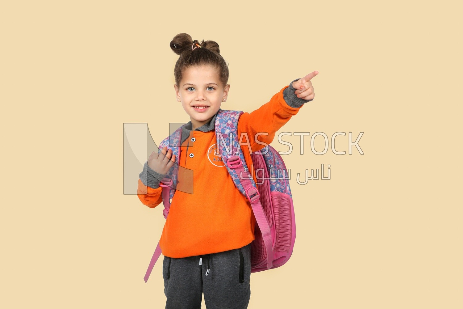 A schoolgirl wearing her bag and pointing