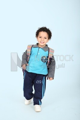 A boy wearing his bag on a blue background