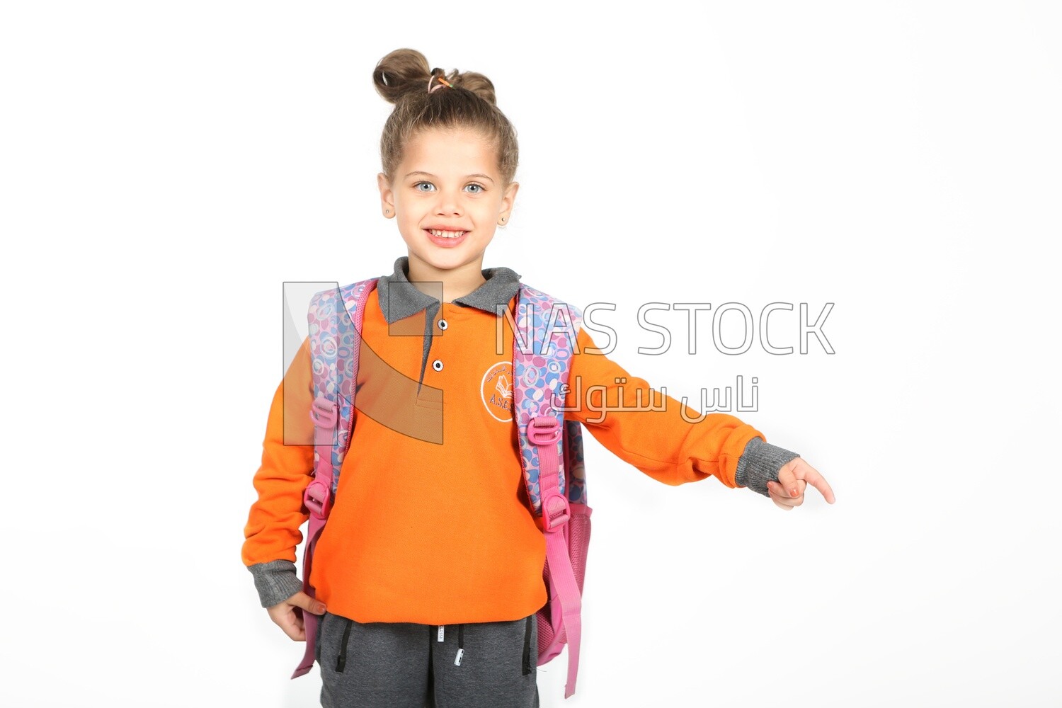 A schoolgirl wearing her bag and pointing