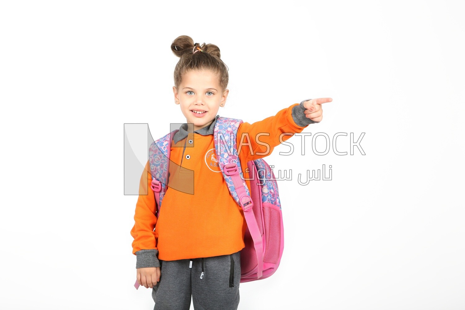 A schoolgirl wearing her bag and pointing