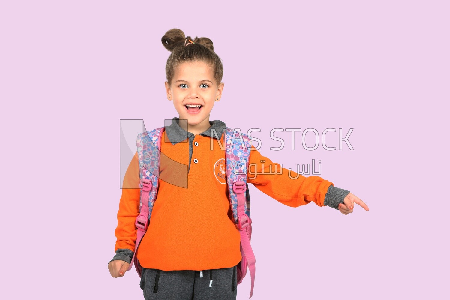 A schoolgirl wearing her bag and pointing
