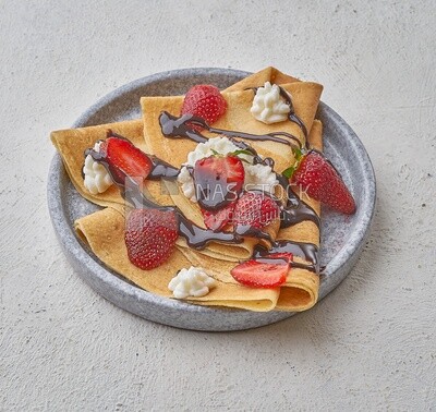 Strawberry crepe with chocolate on a solid background