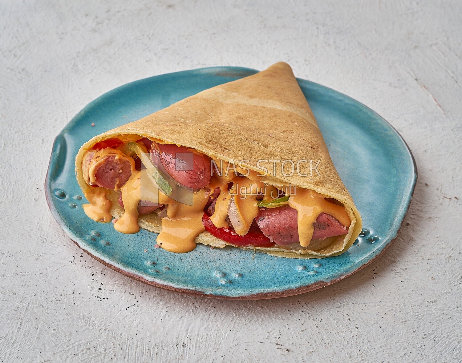 Smoked sausage crepe with melted cheese on a solid background