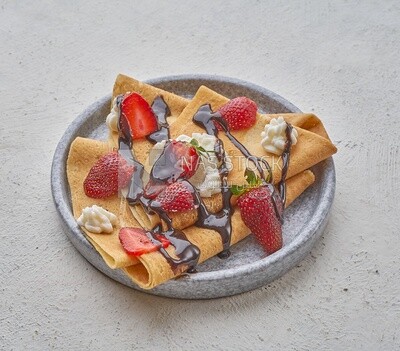 Strawberry crepe with chocolate on a solid background