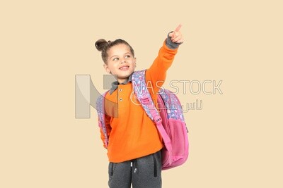 A schoolgirl wearing her bag and pointing