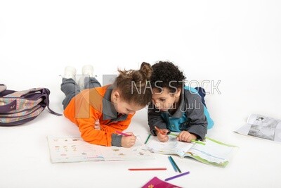 A brother and a sister sitting on the floor studying