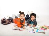 A brother and a sister sitting on the floor studying