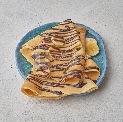 Chocolate crepe with banana slices on a solid background