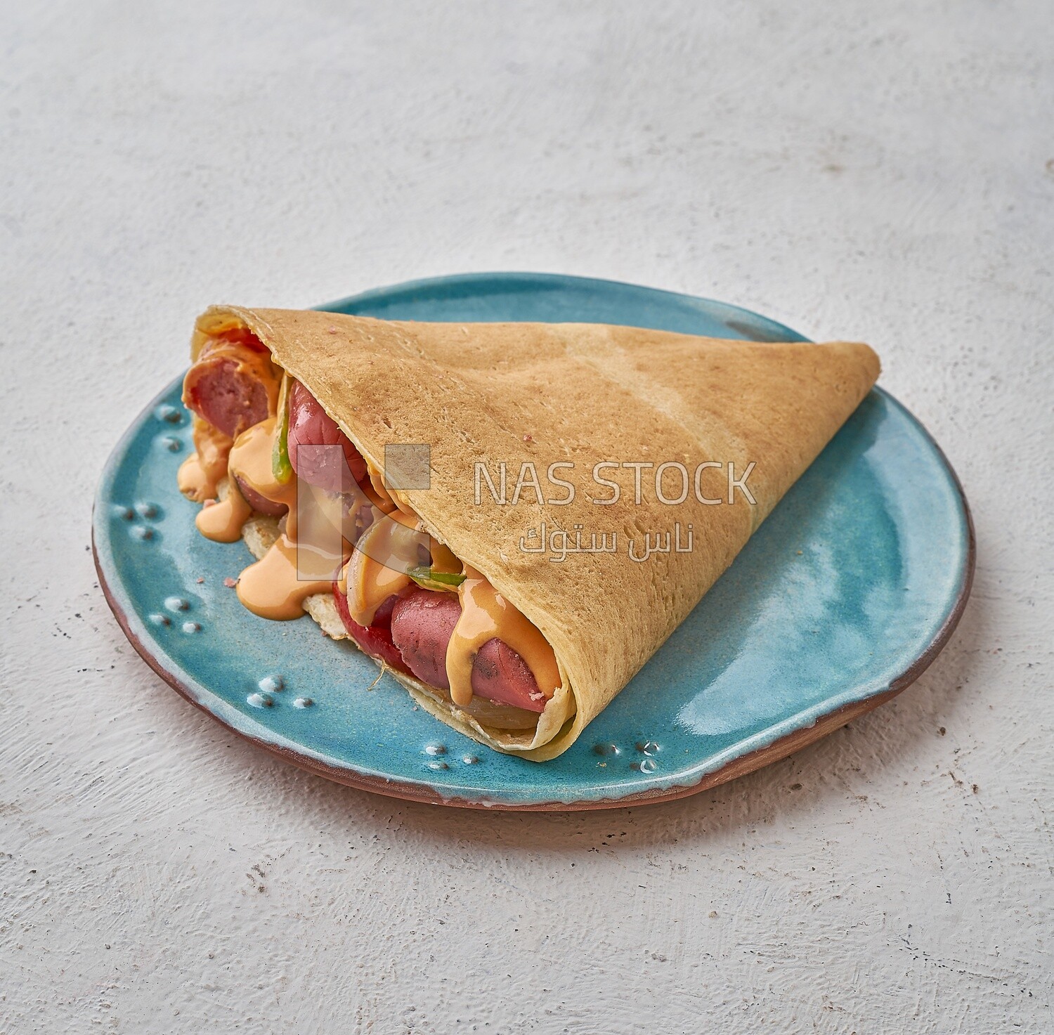Sausage crepe with melted cheese on a solid background