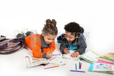A brother and a sister sitting on the floor studying